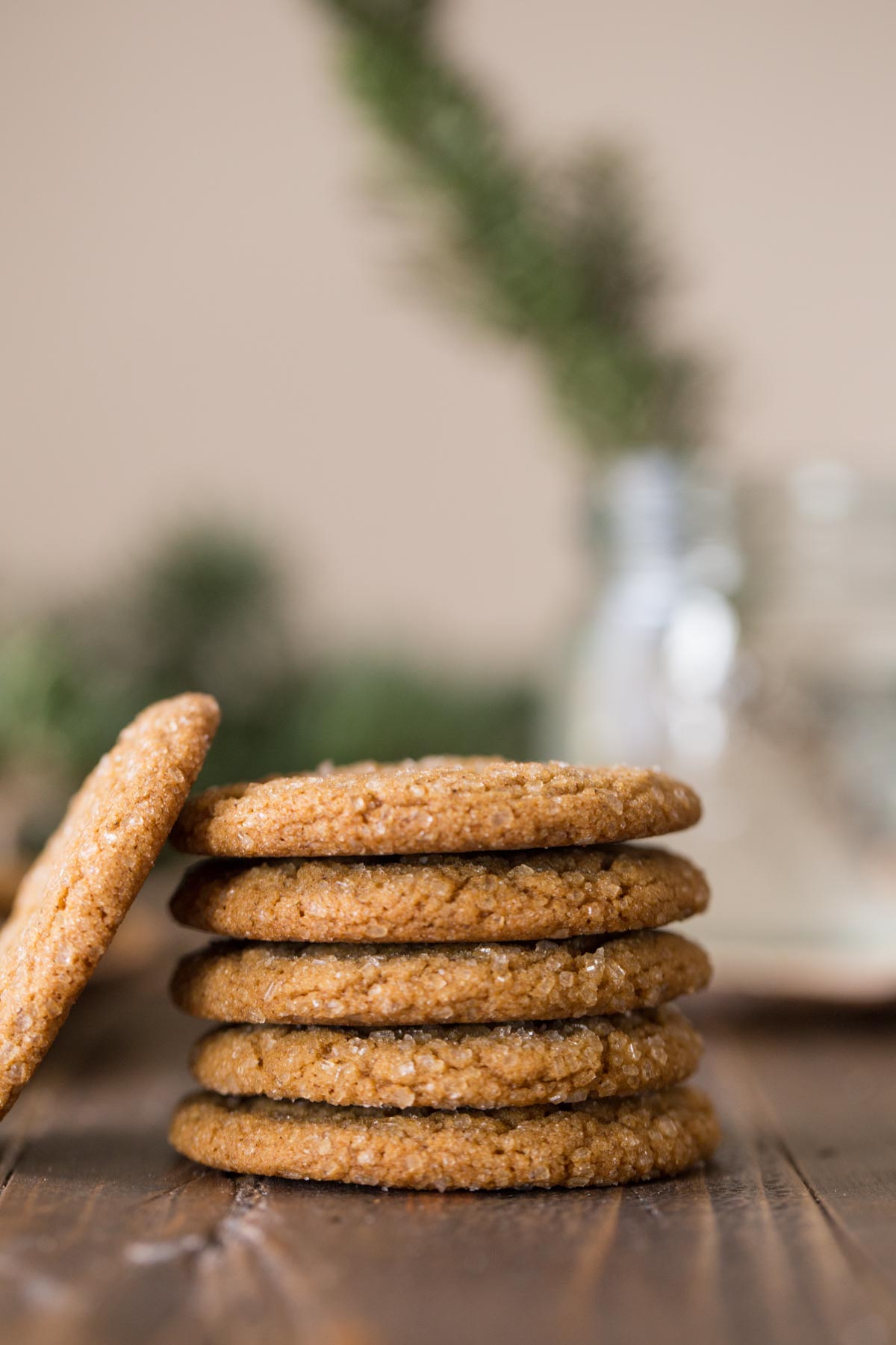Five Old Fashioned Ginger Snaps stacked on top of each other, with one Old Fashioned Ginger Snap leaning against the stack. 