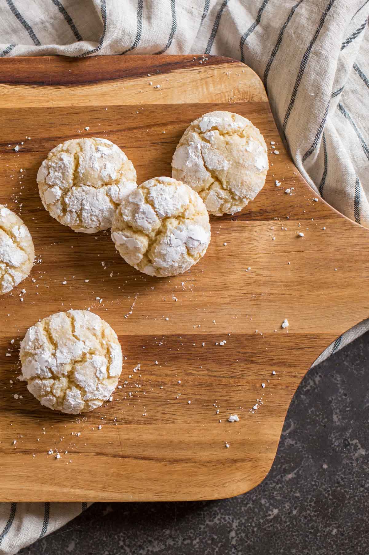 Brown Butter Almond Crinkle Cookies on a wood cutting board. 