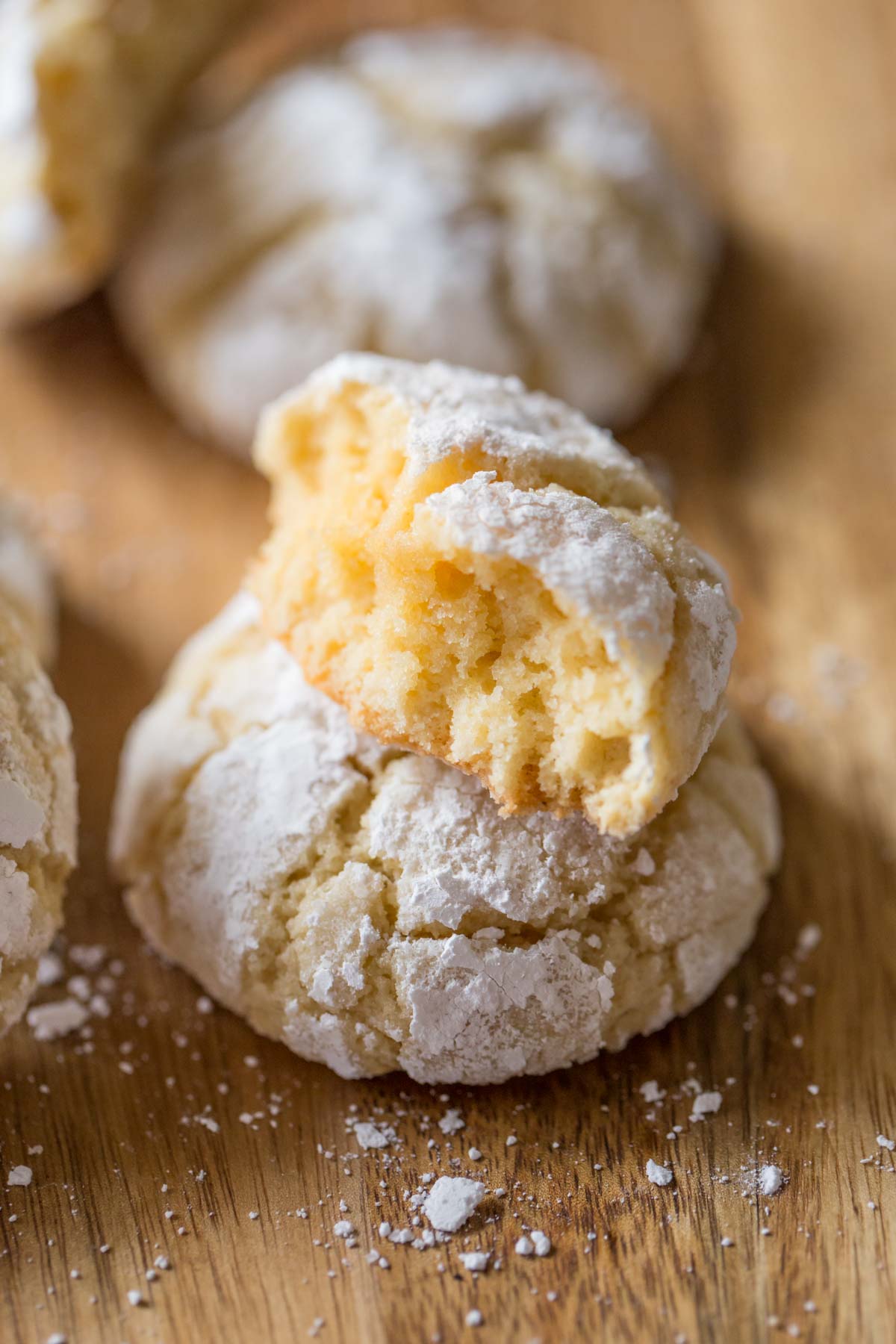 A half of a Brown Butter Almond Crinkle Cookie on top of a whole cookie.  