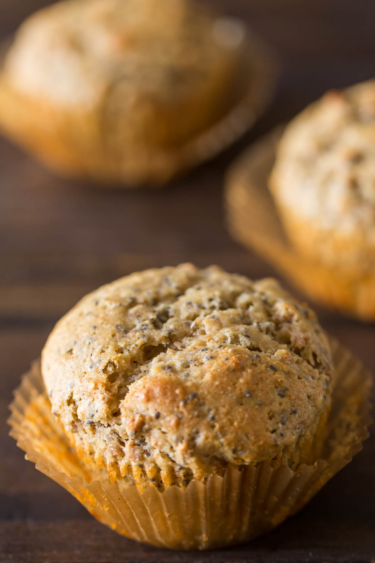 A Honey Bran Muffin with two muffins in the background. 