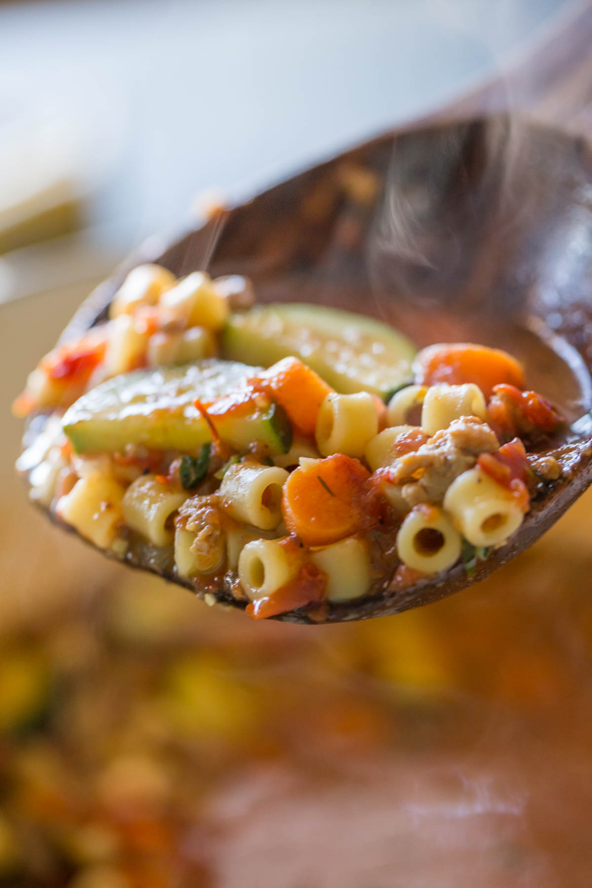 A wood serving spoon full of Turkey and Vegetable Ditalini Soup.  