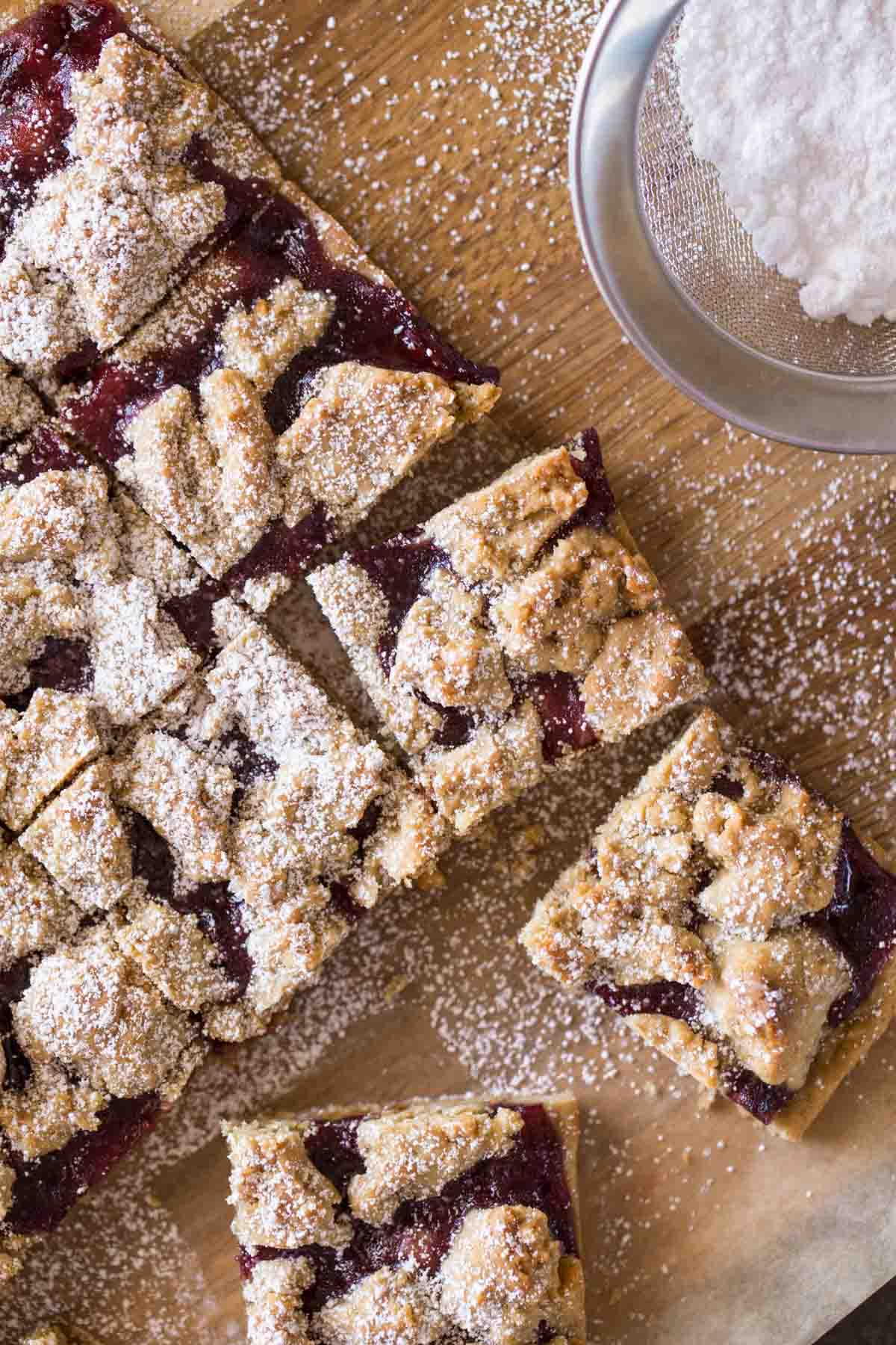 Peanut Butter and Jelly Oat Bars cut into squares and dusted with powdered sugar. 