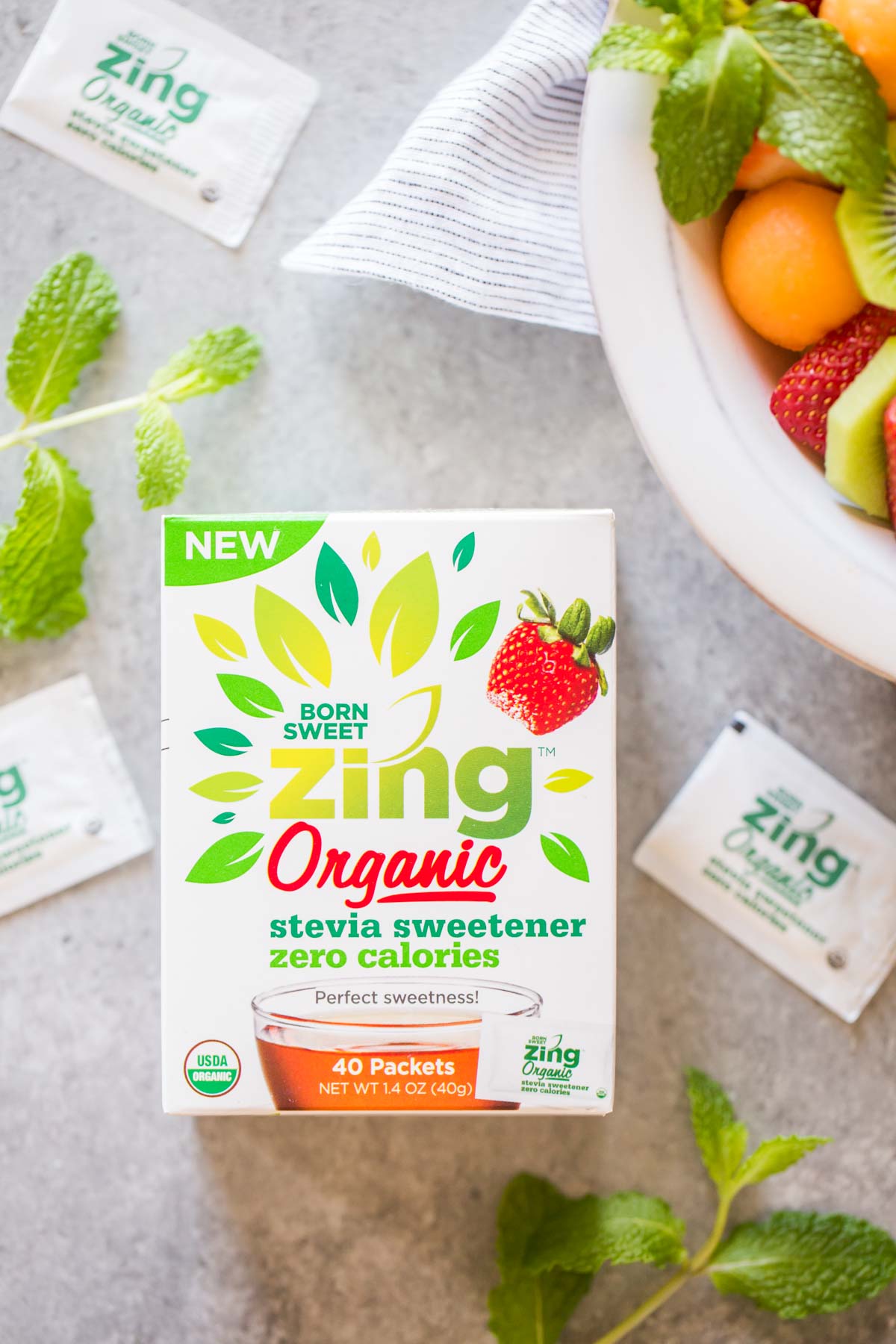 A box of Born Sweet Zing Organic Stevia Sweetener, sitting next to the bowl of Summer Fruit Salad. 
