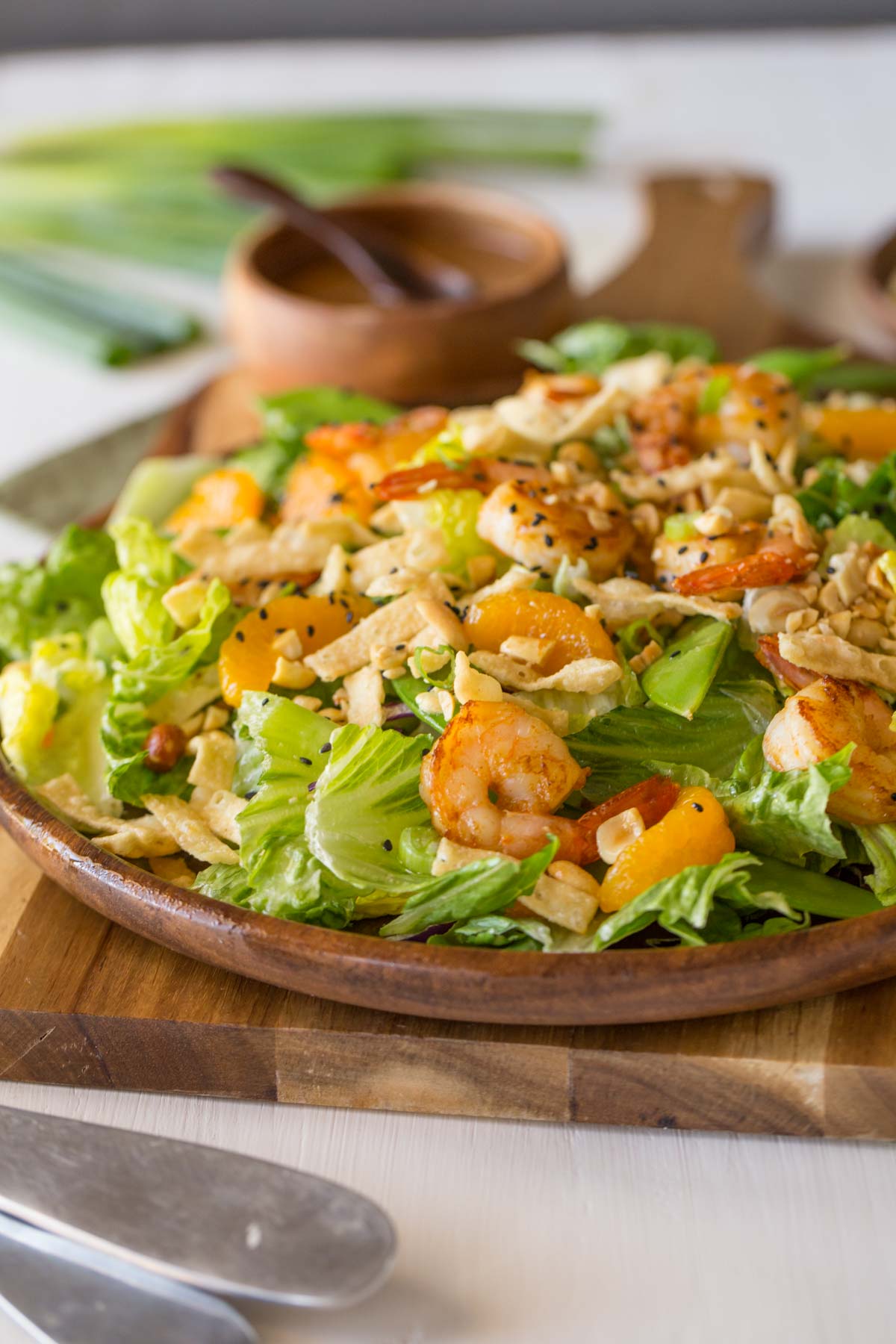 Shrimp Salad on a large serving plate, with a small wood bowl of the Spicy Peanut Dressing in the background.