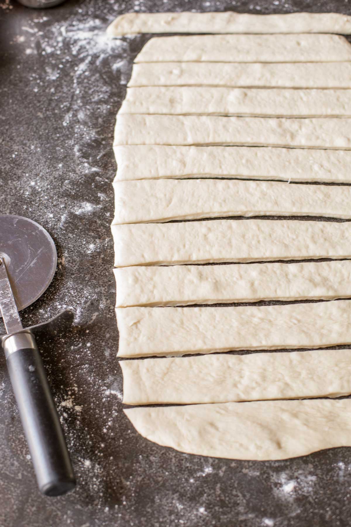 Fresh Buttery Garlic Breadsticks dough cut into strips.