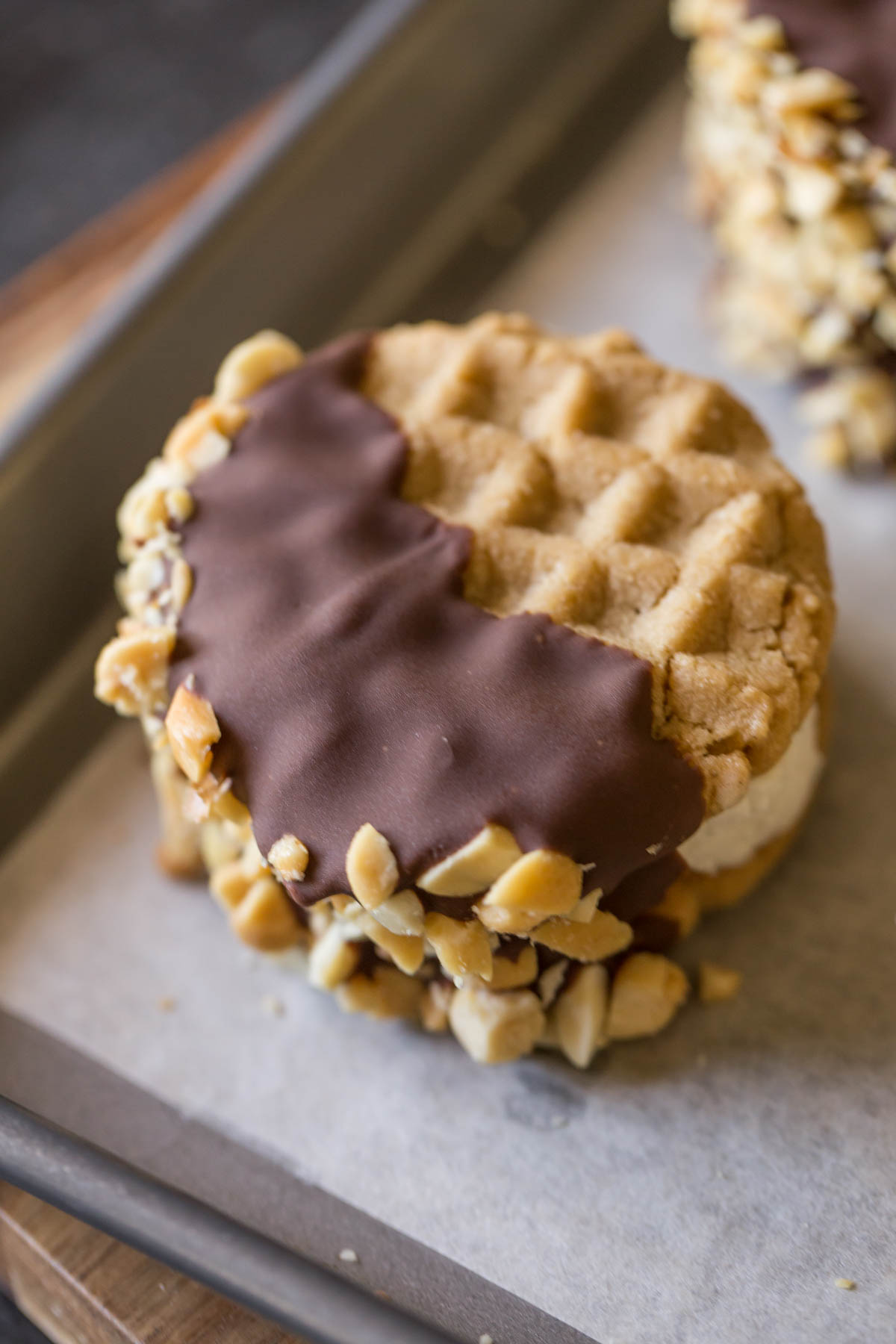 A Peanut Butter Cookie Ice Cream Sandwich on a parchment paper lined baking sheet. 