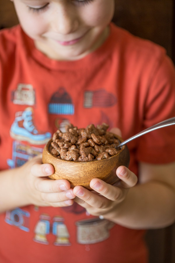 Little boy holding a small bowl of Annie's Cocoa Bunnies. 