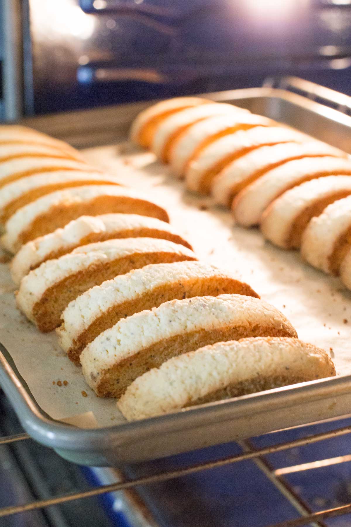 Almond Poppy Seed Biscotti on a parchment paper lined baking sheet in the oven. 