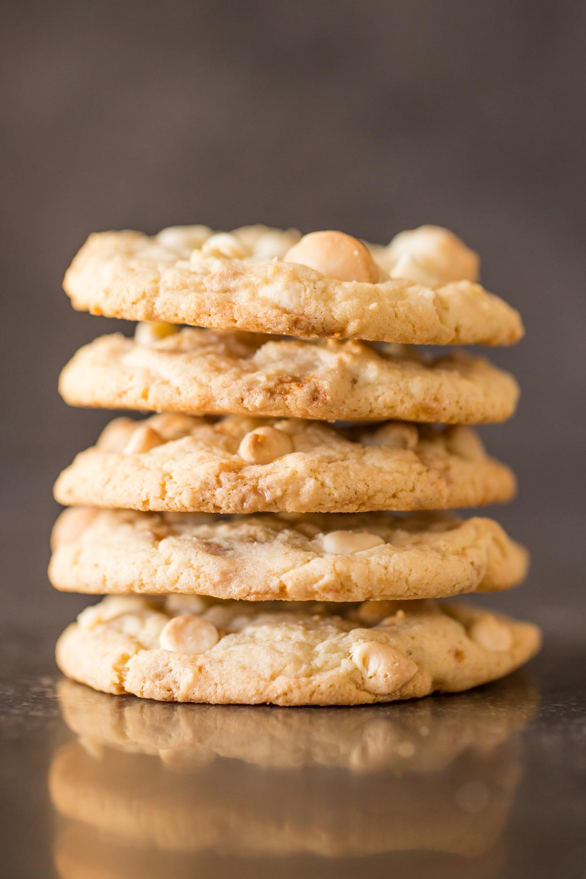 Five Buttery Toffee White Chocolate Chip Macadamia Nut Cookies stacked on top of each other.  