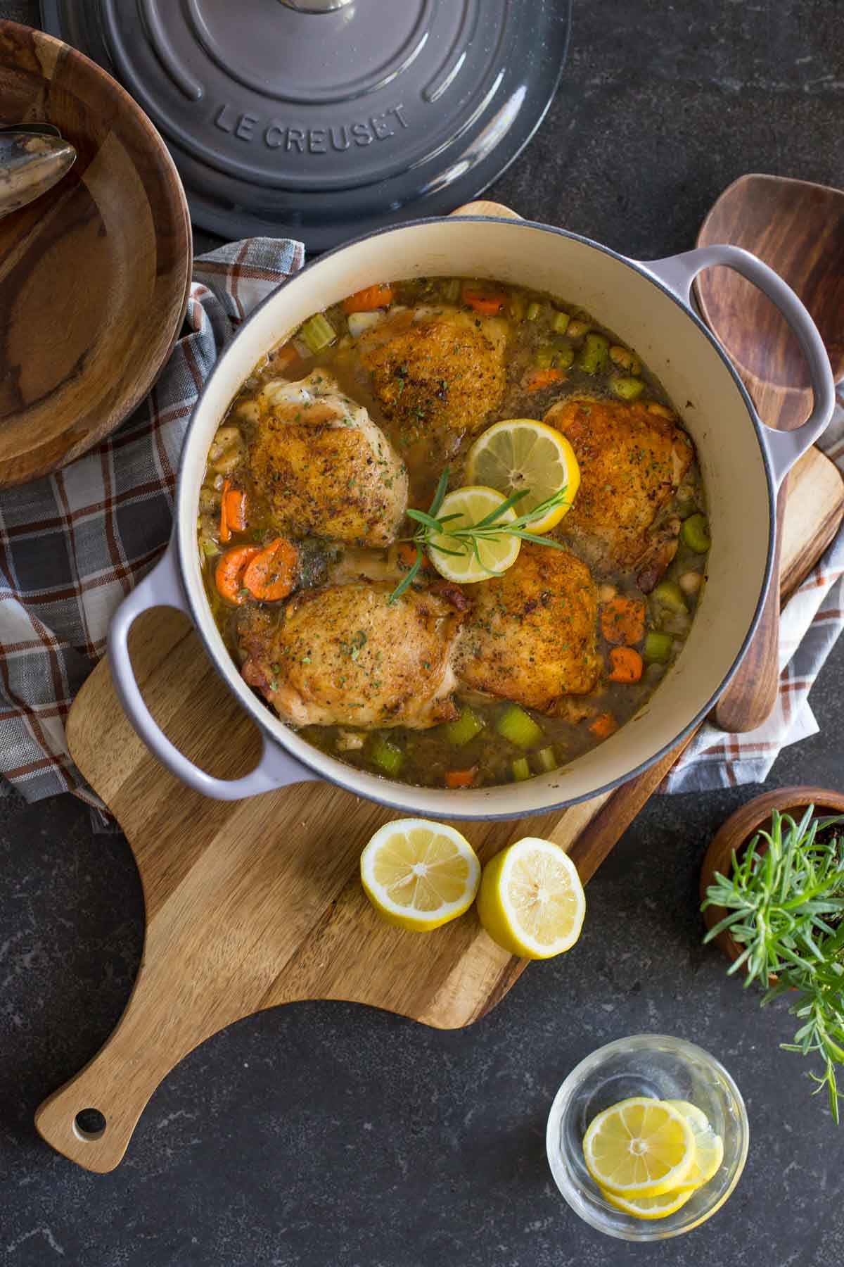 Rustic Lemon Rosemary Chicken and Orzo in a Le Creuset Dutch oven, garnished with rosemary and lemon slices. 