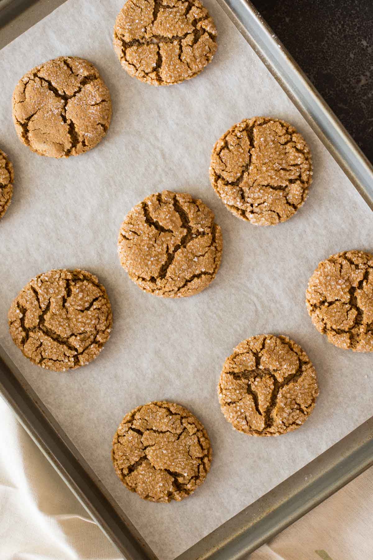 Peanut Butter Molasses Cookies on a parchment paper lined baking sheet. 