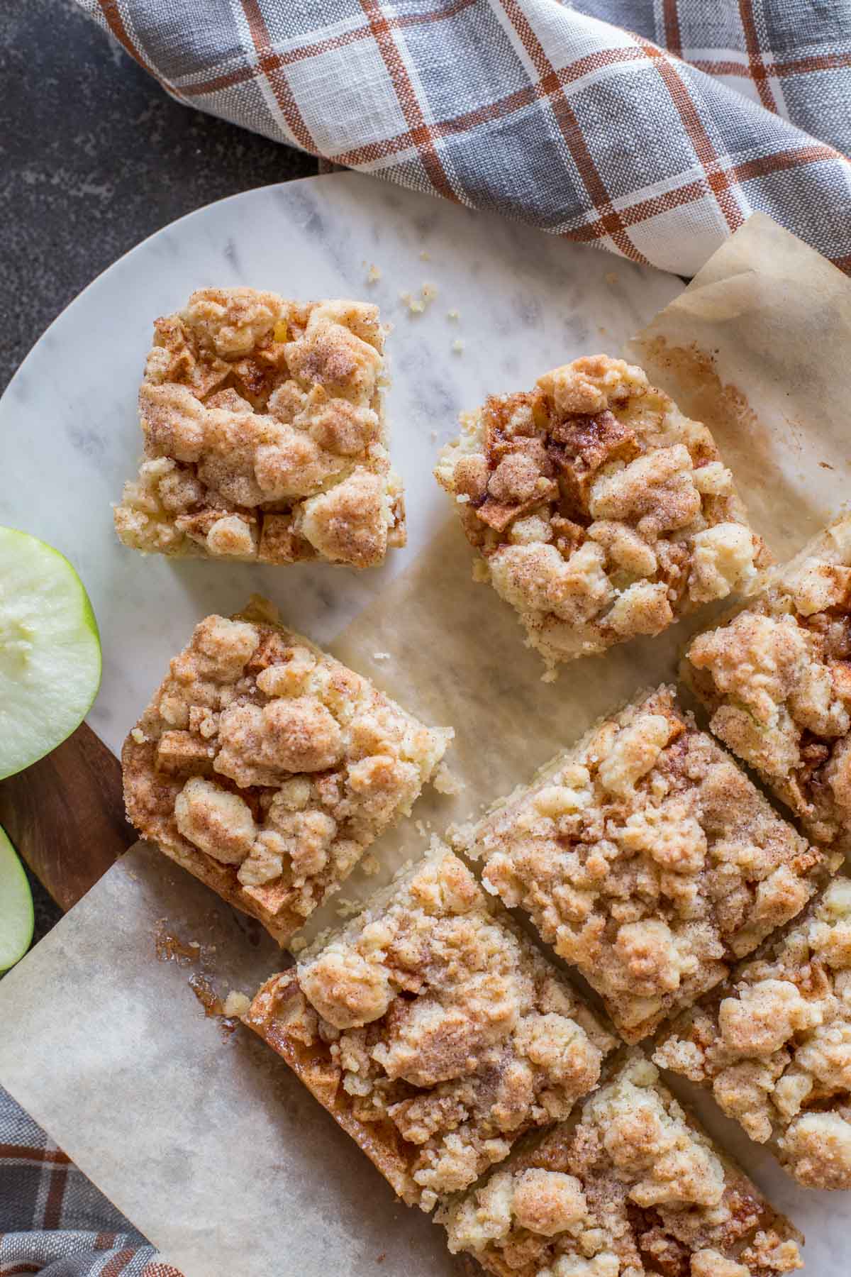 Apple Pie Crumb Bars on a marble and wood cutting board. 