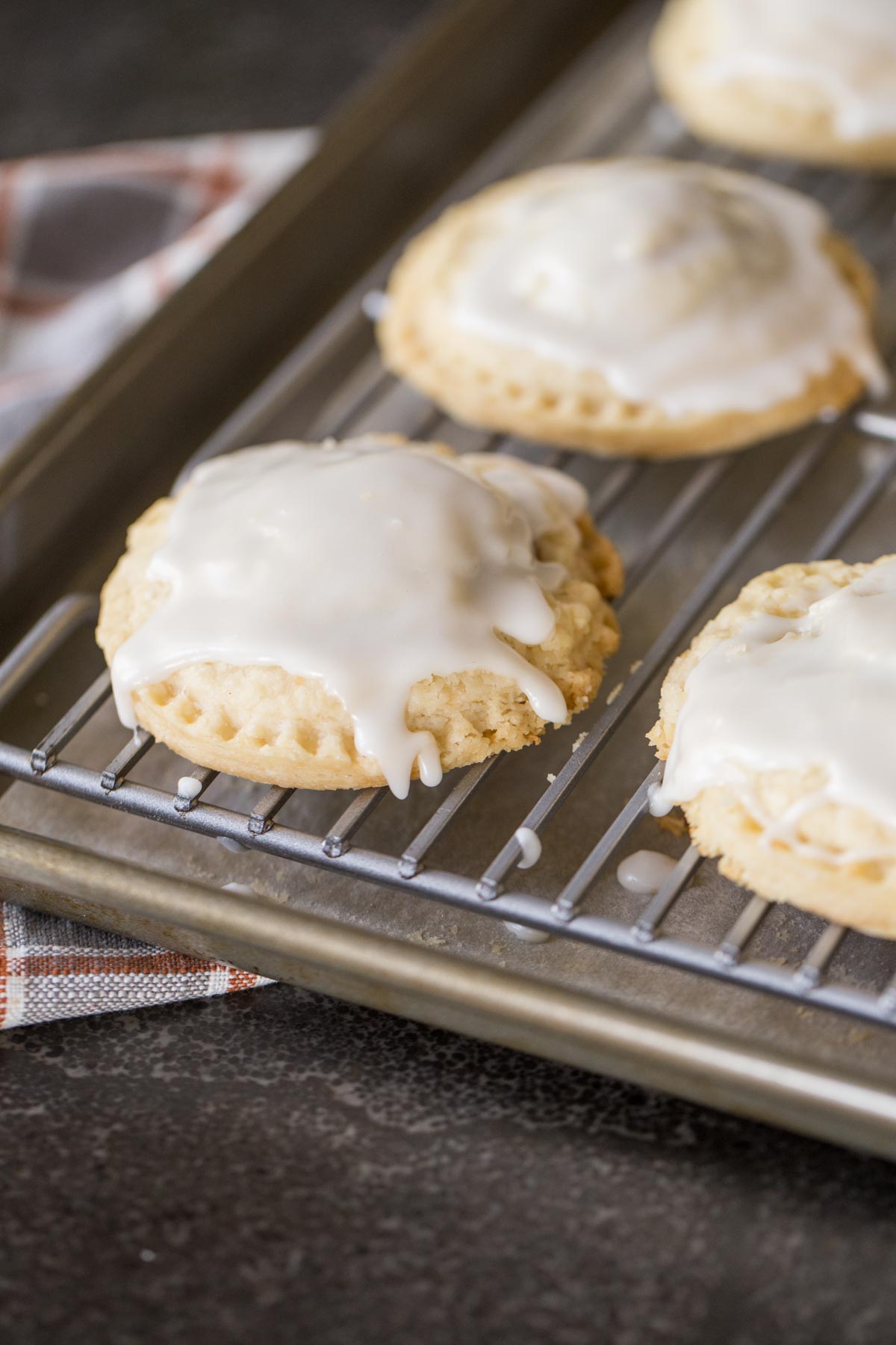 Glazed Pumpkin Hand Pies on a cooling rack that is on a baking sheet.  