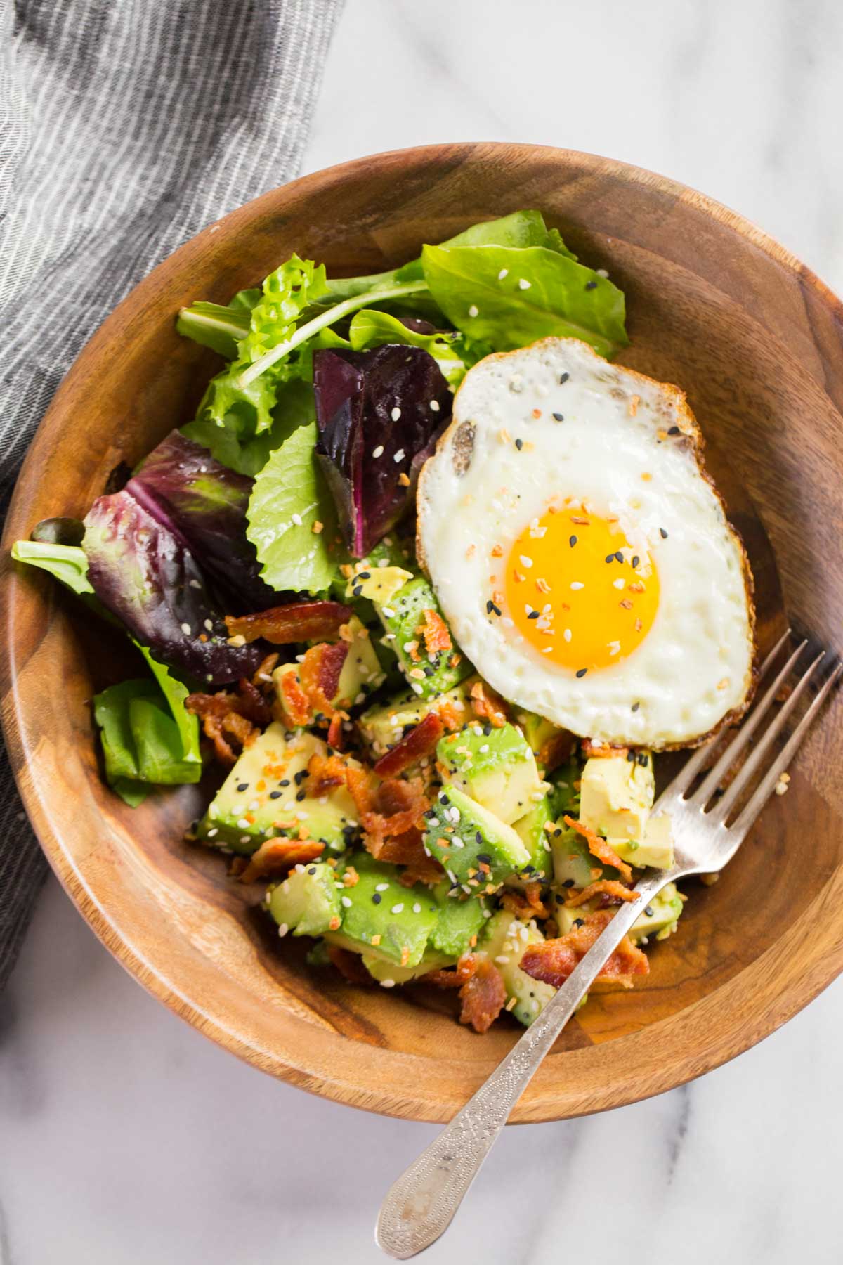 Avocado Breakfast Bowl in a wood bowl with a fork.  