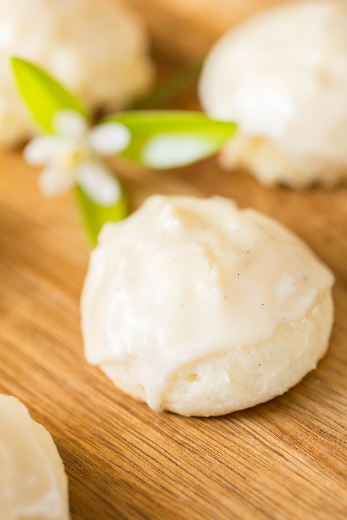 A close up shot of an Orange Ricotta Cookie with a vanilla glaze on top. 