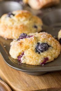 A close up view of Best Ever Buttermilk Blueberry Muffins in a muffin pan.