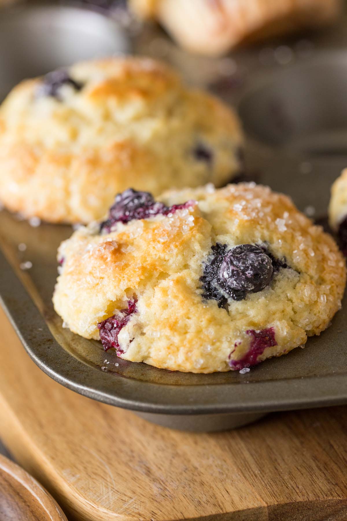 A close up shot of the Best Ever Buttermilk Blueberry Muffins in a muffin pan. 