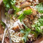 Israeli Couscous Salad with Honey Lemon Vinaigrette in a wooden bowl on a wooden cutting board.