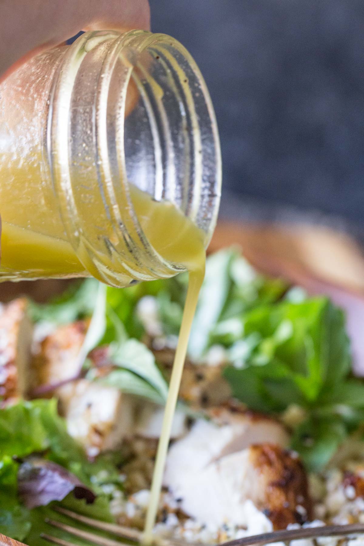 Israeli Couscous Salad with Honey Lemon Vinaigrette pouring out of a mason jar.