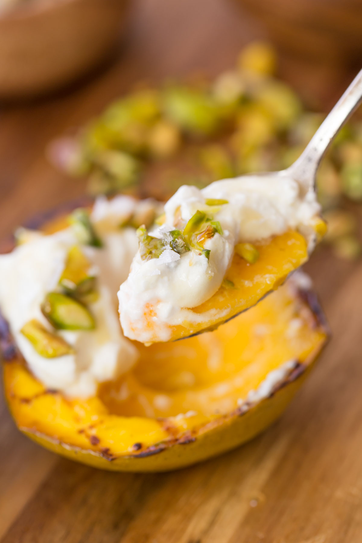 Grilled Mango With Honey Ricotta Whipped Cream with spoonful in the foreground. 