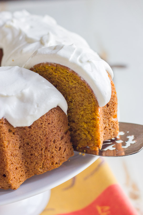 A close up view of a slice of pumpkin spice bundt cake on a cake serve.
