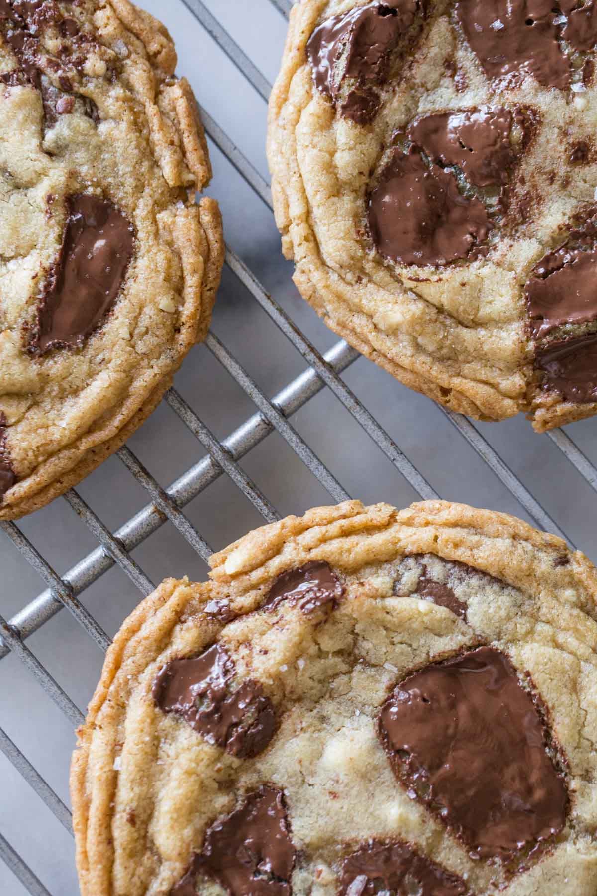 Close up view of Toffee Almond Chocolate Chunk Cookies on a cooling rack. 