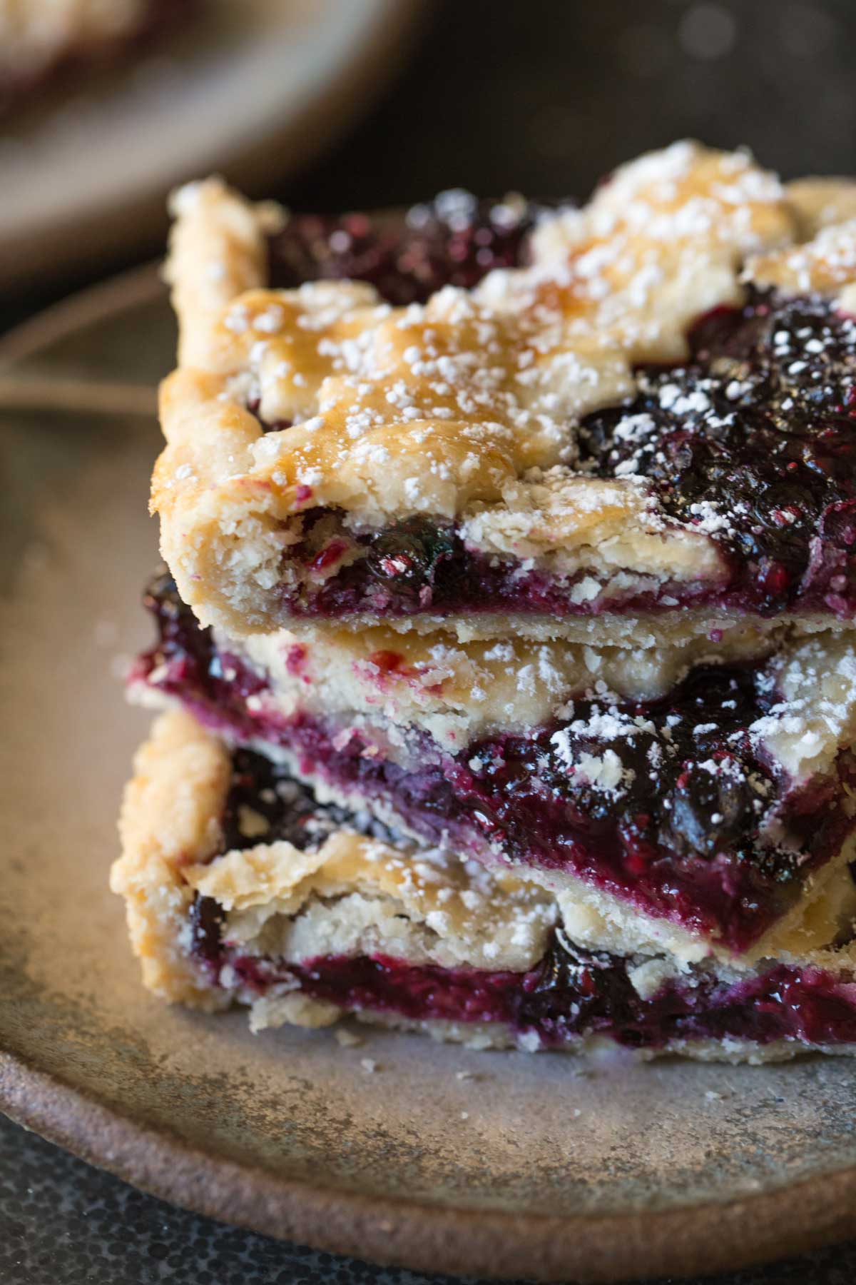 A close up of three pieces of Triple Berry Slab Pie stacked on a plate. 