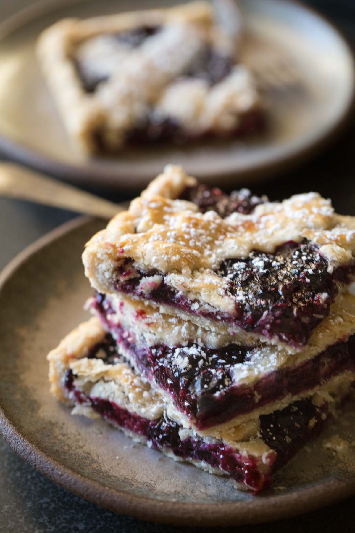 Three slices of Triple Berry Slab Pie stacked on a plate. 