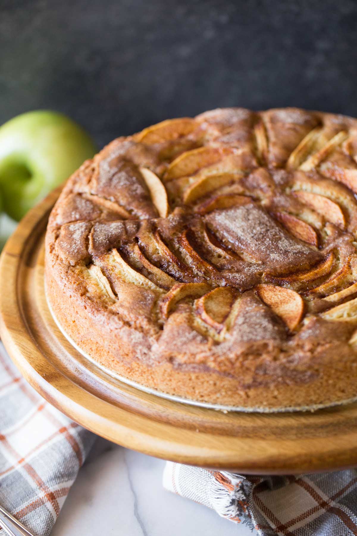 Apple Cider Cake from the front view on a wooden cake stand. 