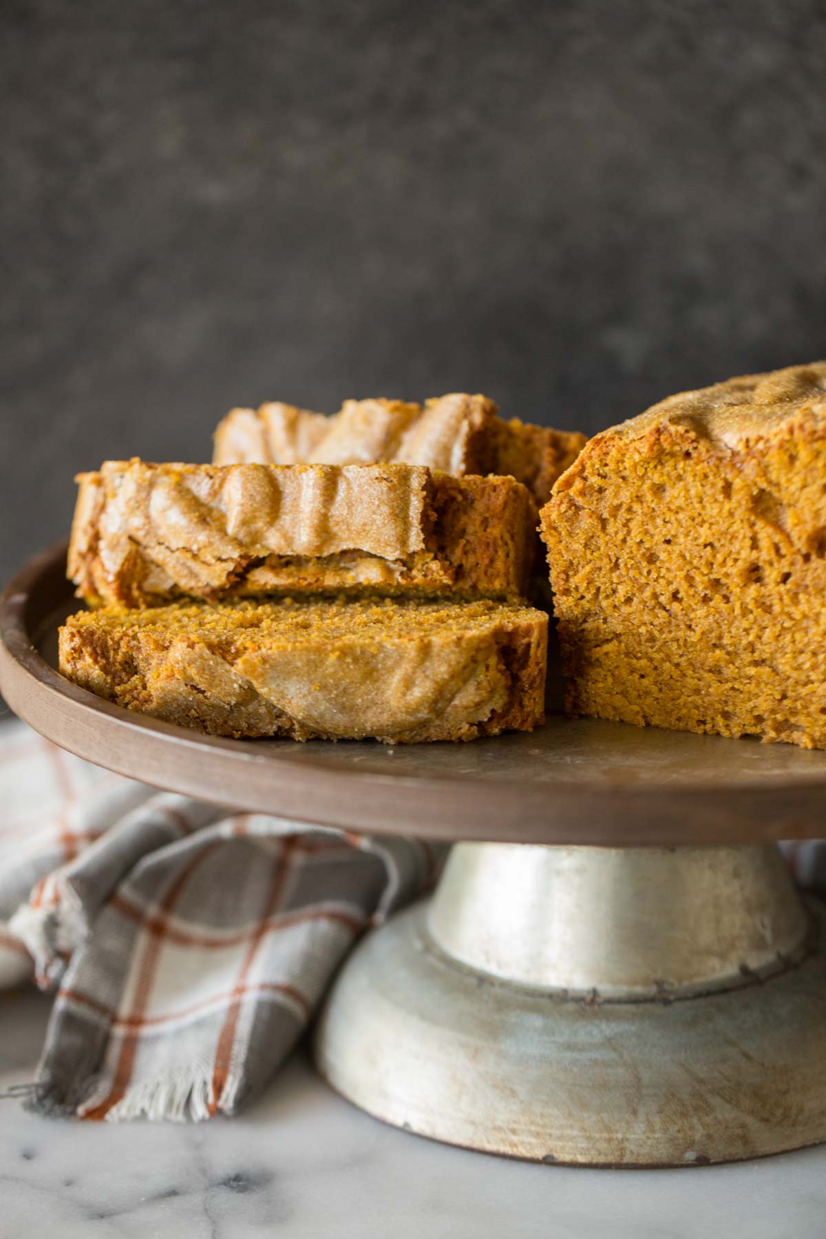Slices of Easy Pumpkin Bread on a metal cake stand. 