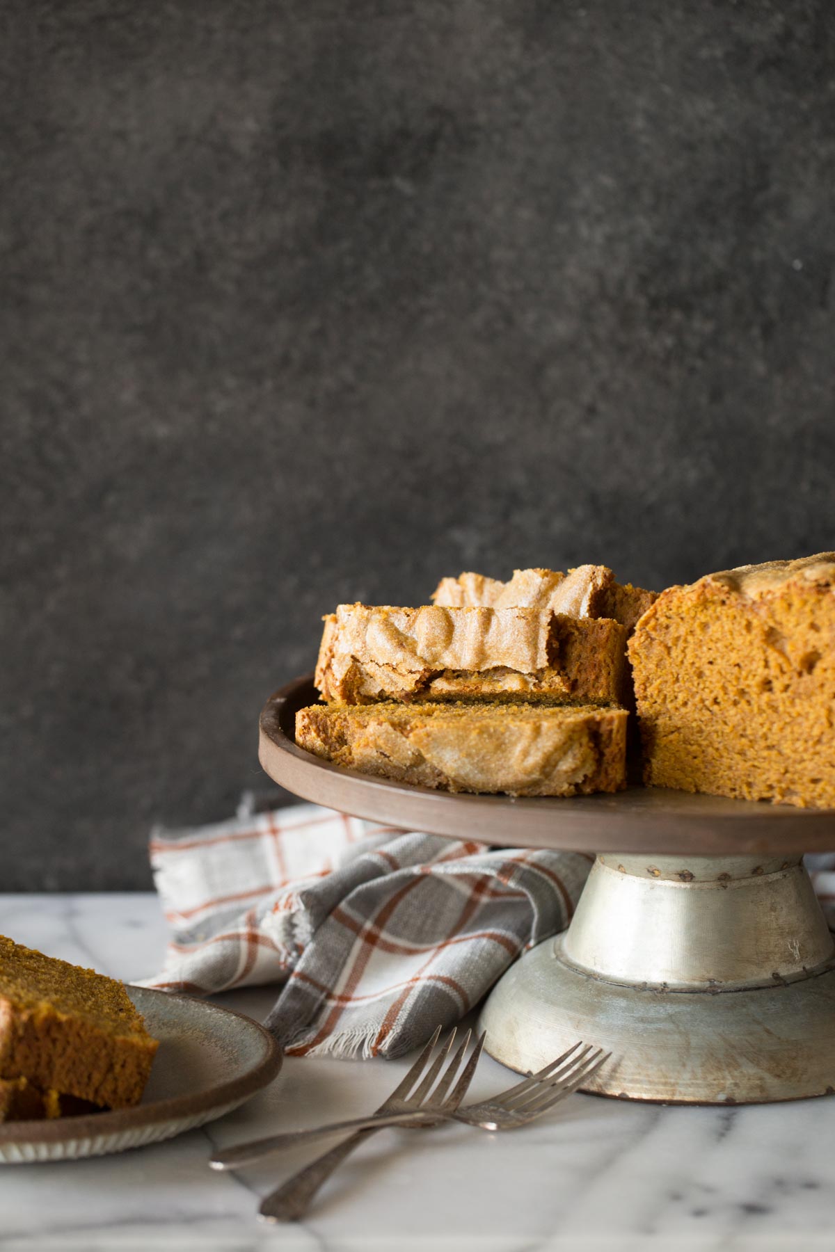 Slices of Easy Pumpkin Bread on a metal cake stand. 