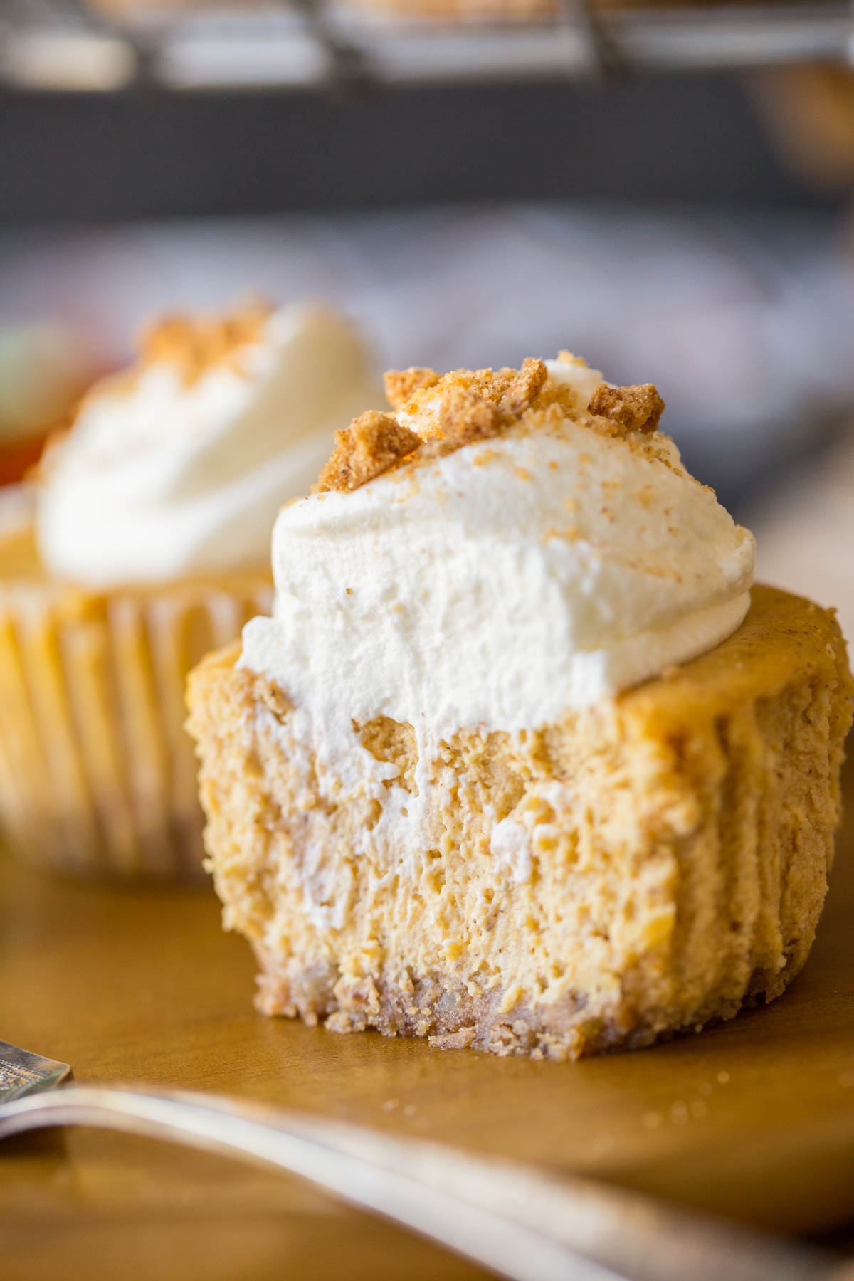 Close up shot of the inside of pumpkin spice cheesecakes topped with whipped cream