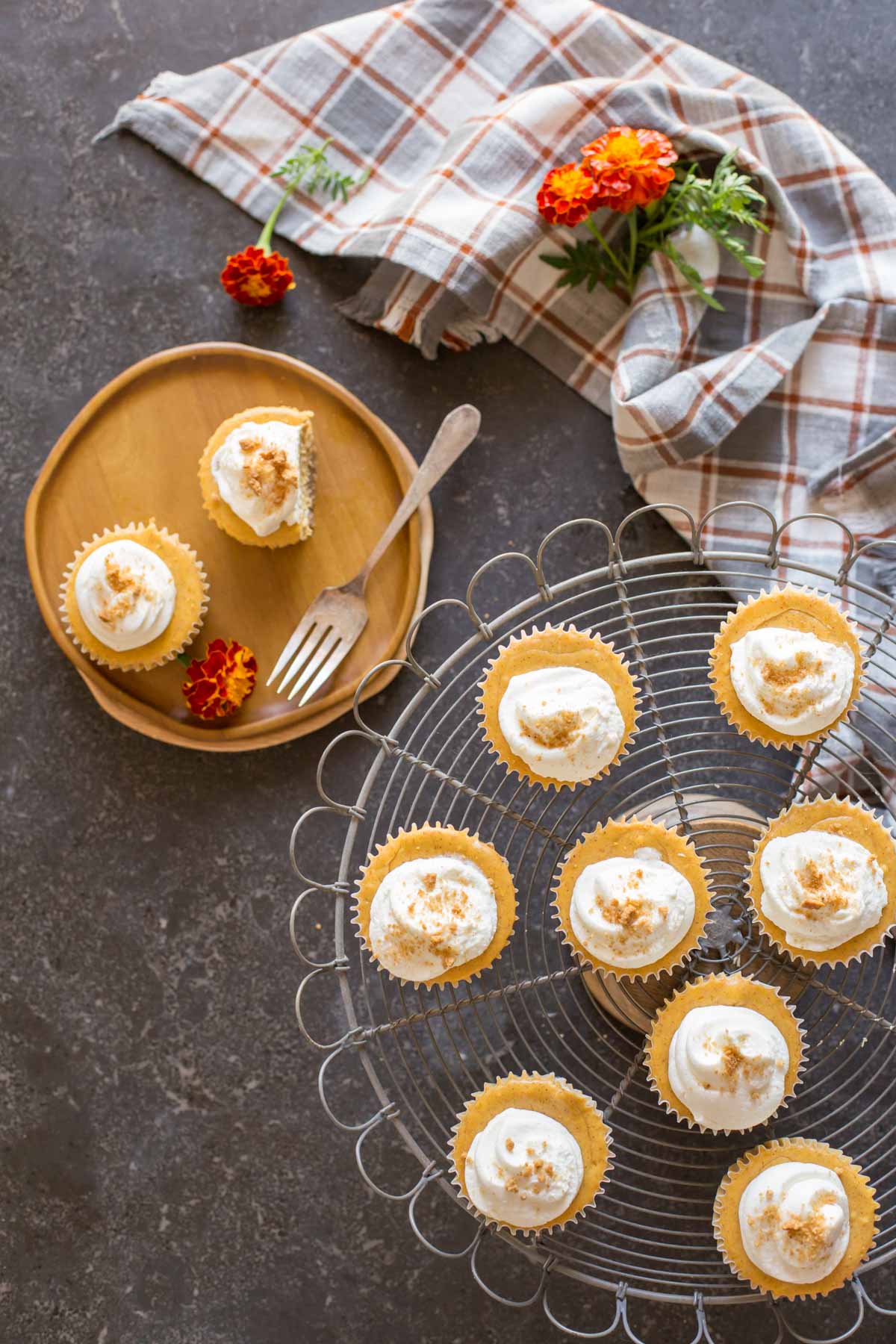 Top down view of Mini Pumpkin Spice Cheesecakes on a cake server and plate with whipped cream on top. 