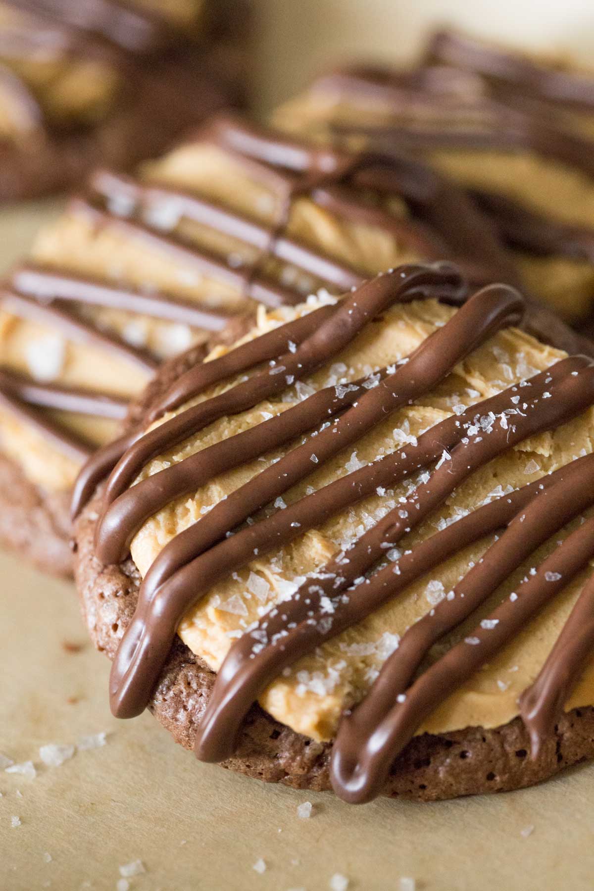 Close up shot of Peanut Butter Buckeye Brownie Cookies on a parchment paper lined baking sheet. 