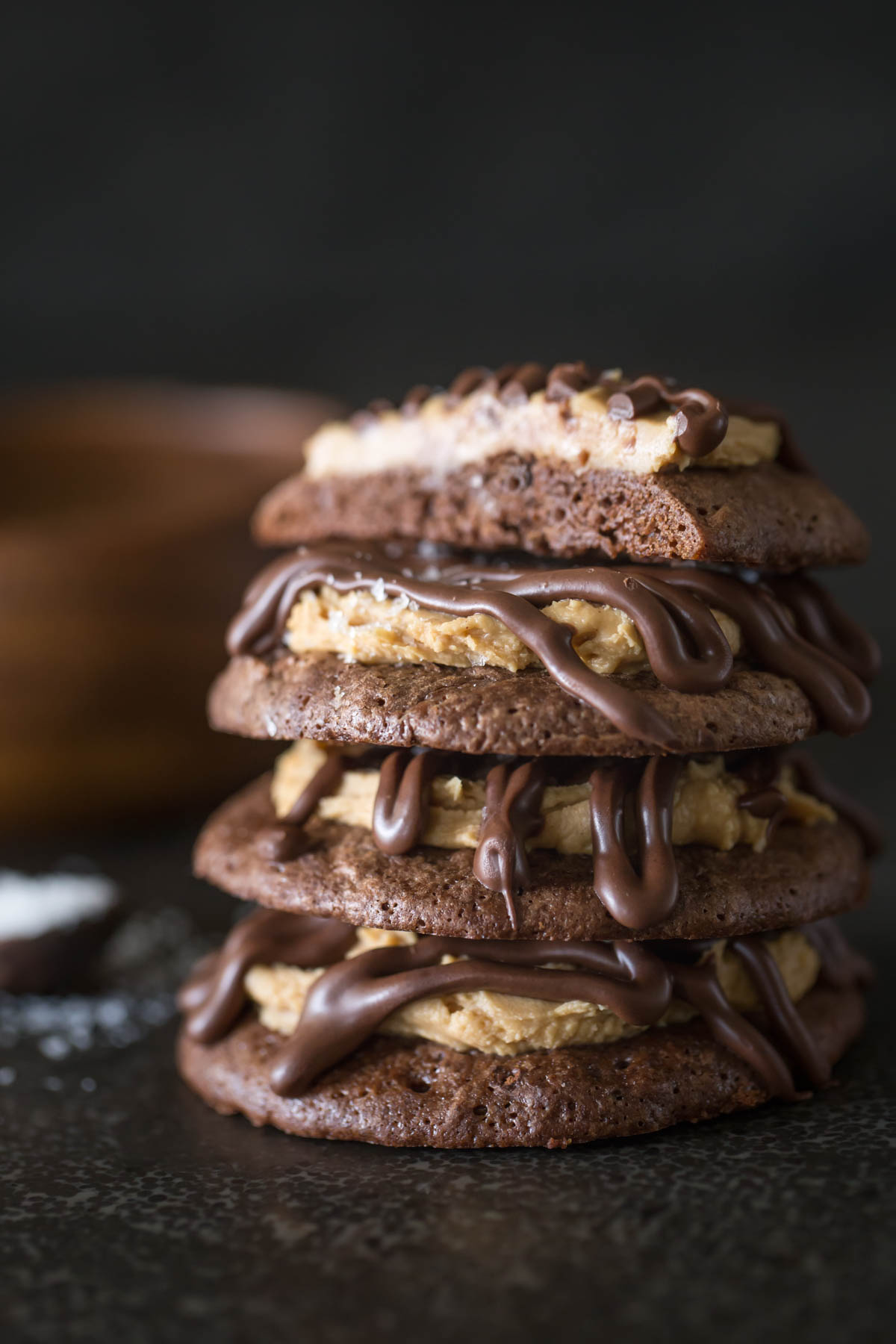 Stack of Peanut Butter Buckeye Brownie Cookies on a grey background. 