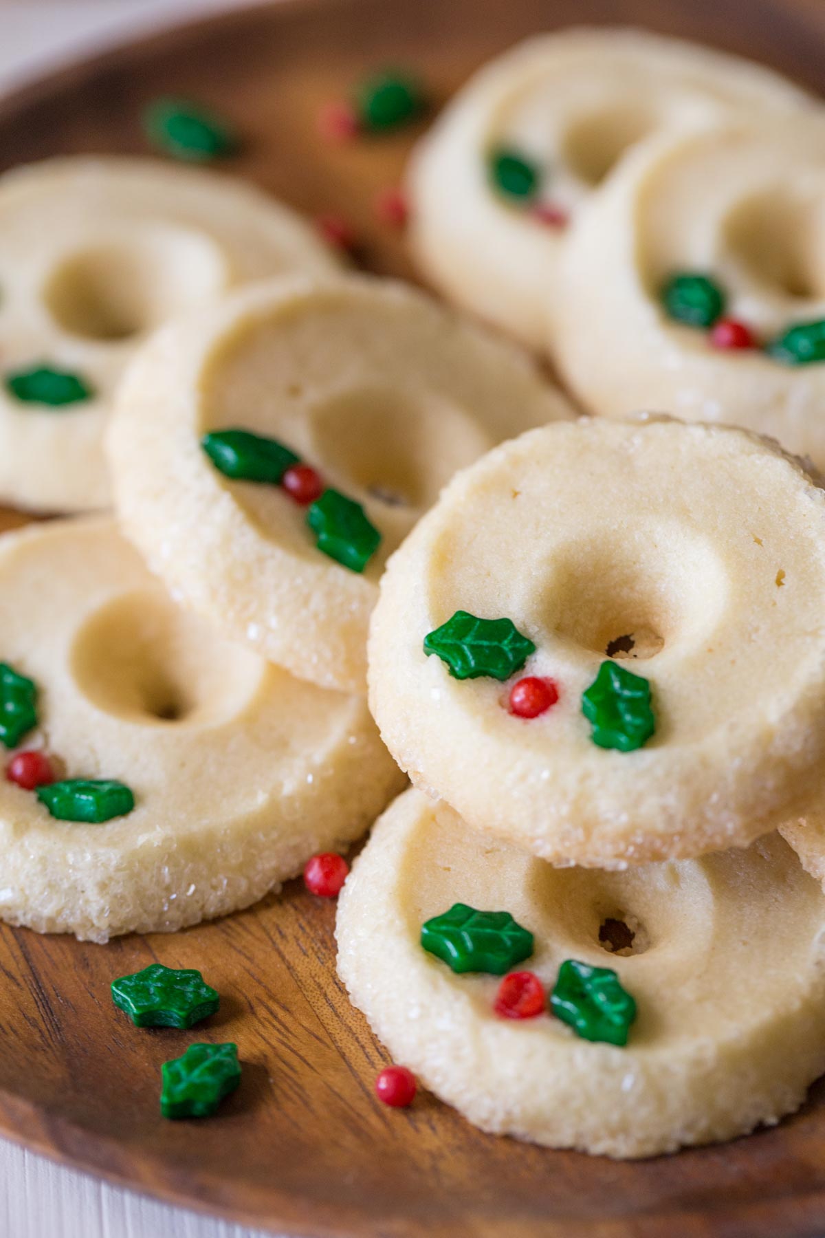 Close up view of Slice and Bake Shortbread Cookies on a wooden plate shaped like a Christmas wreath. 