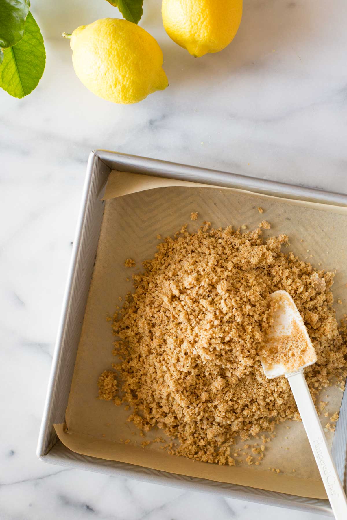 Overhead view of in process shot of making graham cracker crust on a marble slab.