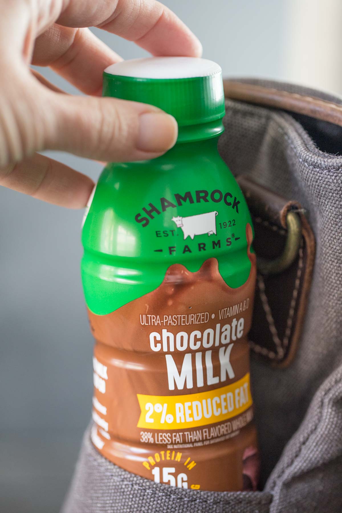 Close up of Shamrock Farms chocolate milk single serve size in the side pocket of a laptop bag.