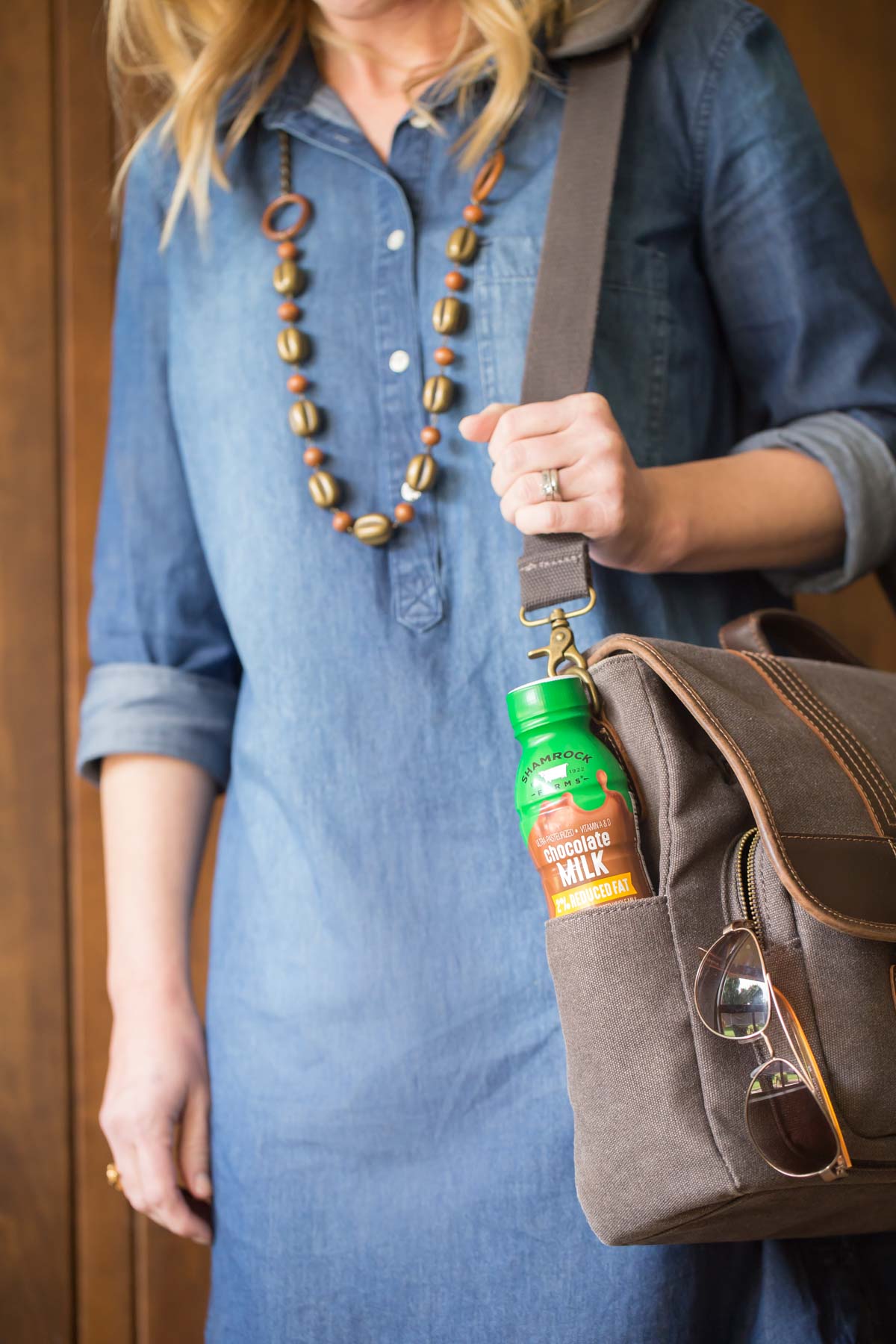 Girl with chocolate milk in the side pocket of a grey laptop bag.