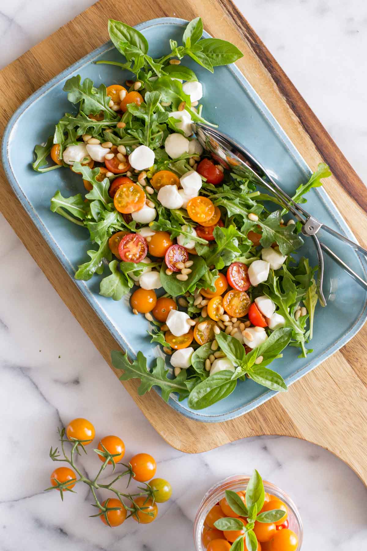 Overhead view of Sungold Caprese Salad on a blue platter. 