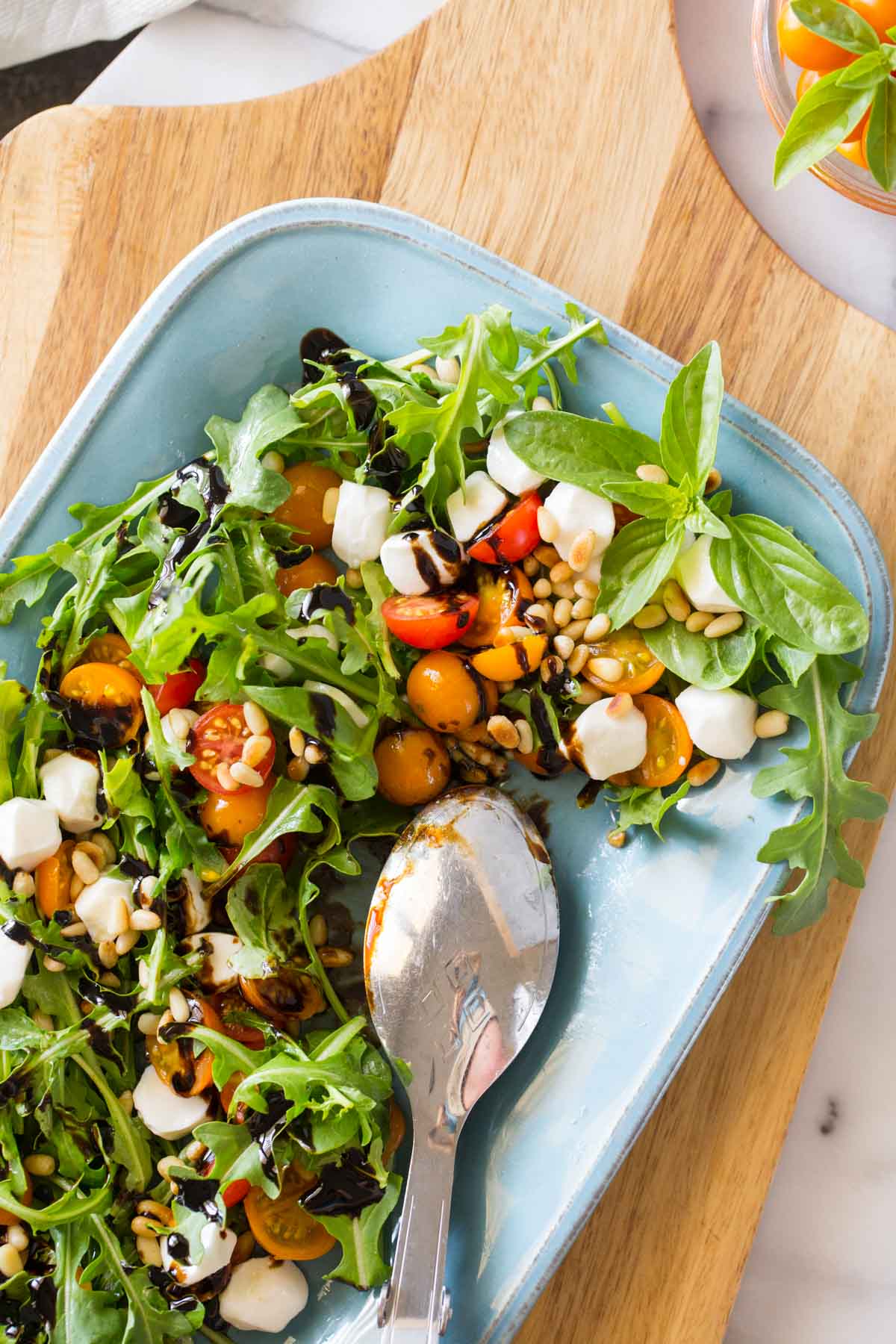 Overhead view of Sungold Caprese Salad on a blue platter. 