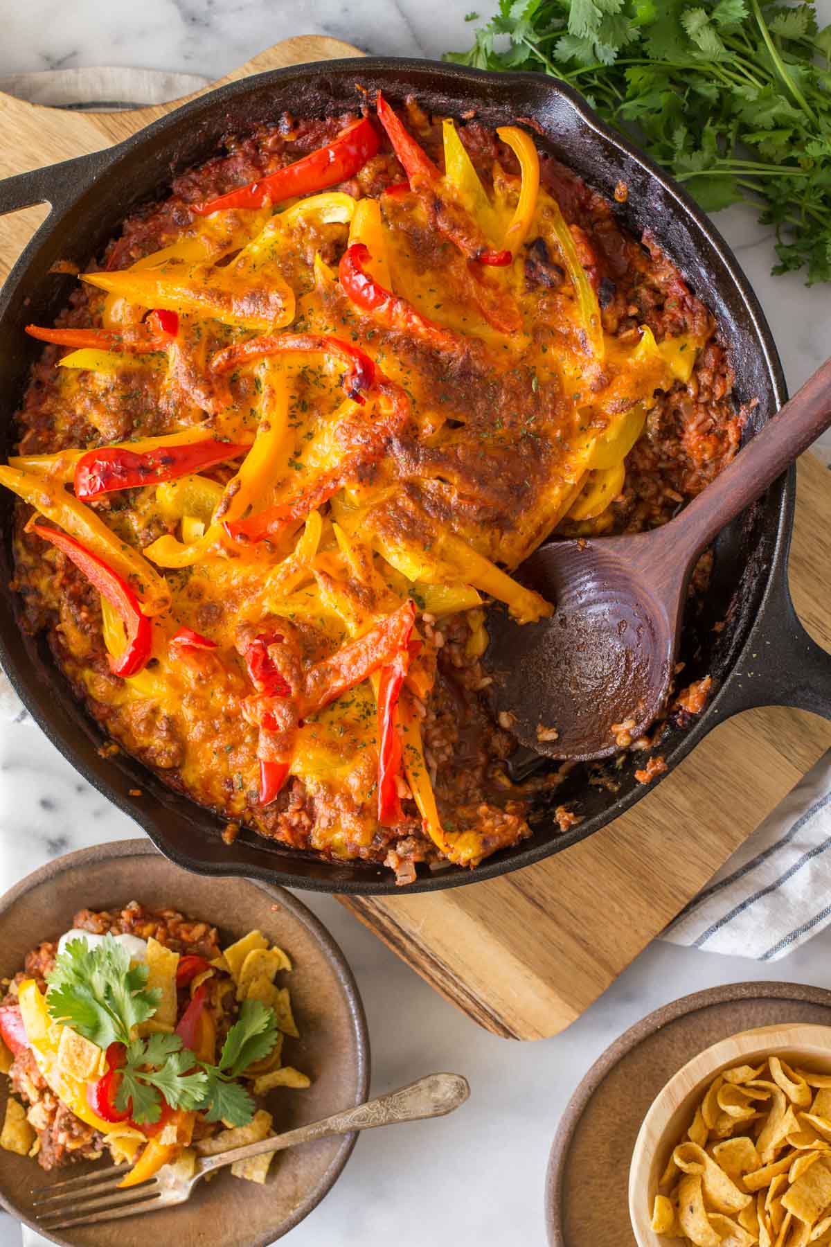 Overhead view of Unstuffed Pepper Skillet on a white marble board with a wooden serving spoon.  