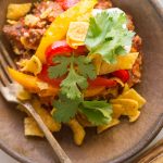 Overhead view of Unstuffed Pepper Skillet in a bowl topped with Fritos, cilantro and sour cream.