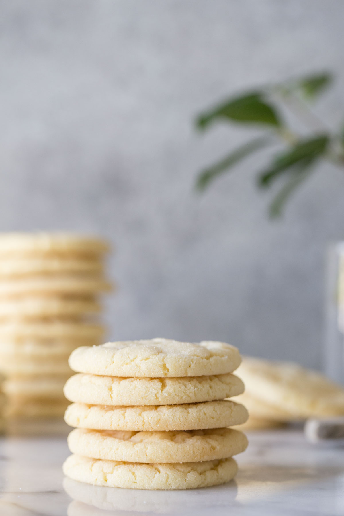 Stack of Soft and Chewy Sugar Cookies on a white and grey background. 