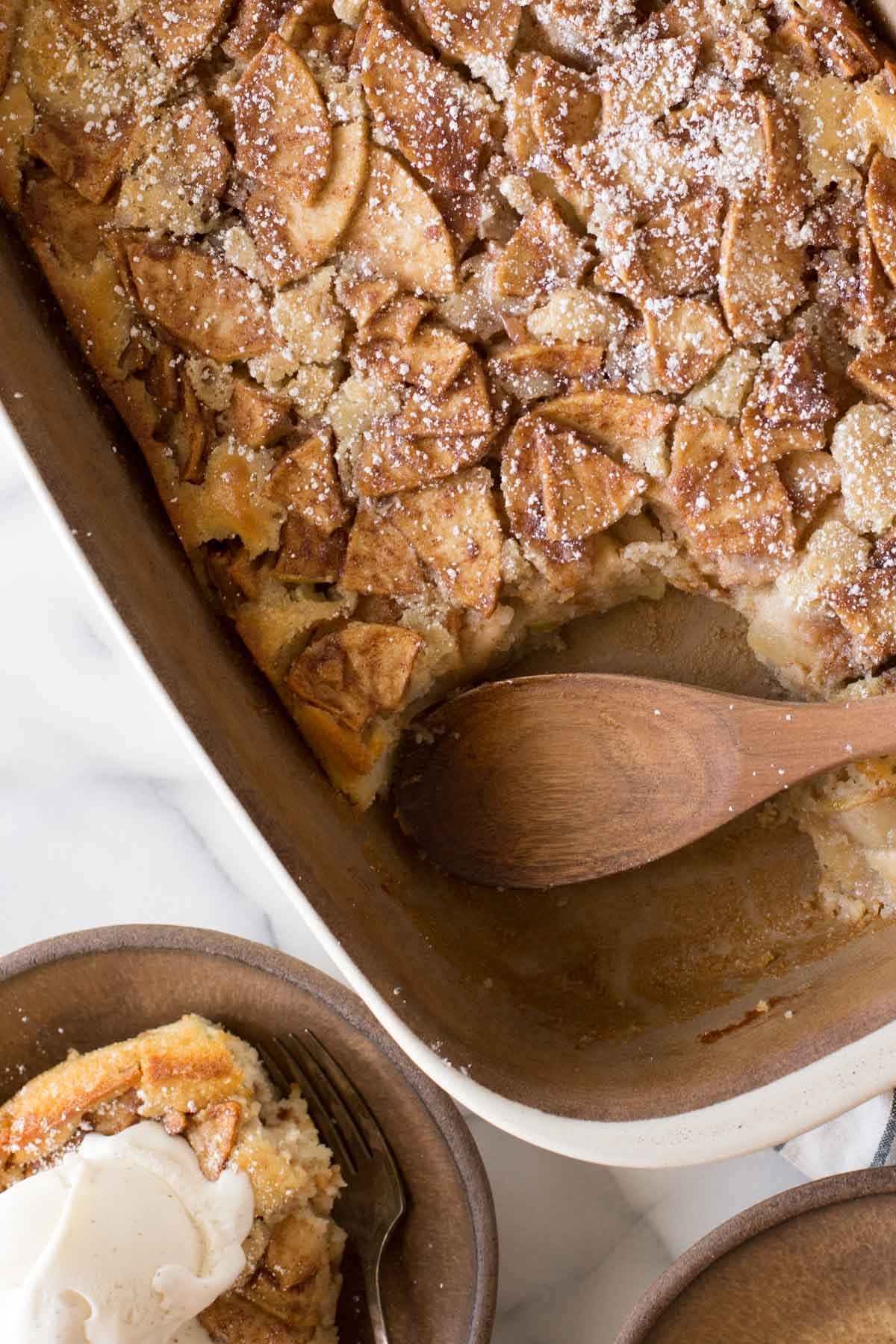 Overhead view of Apple Cobbler with a wooden spoon in the dish. 