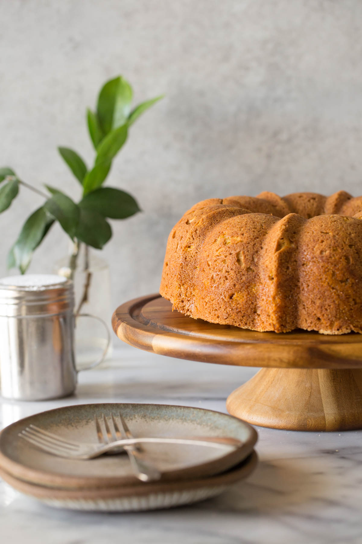 Apple Pumpkin Cake on a cake stand with a grey background. 