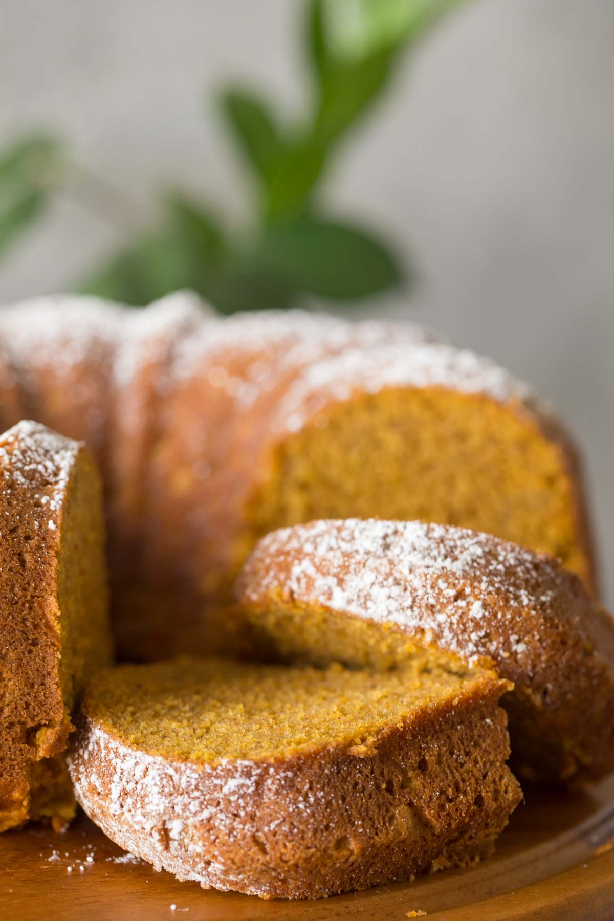 Sliced Apple Pumpkin Cake on a wooden cake stand. 