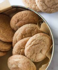 Overhead view of Super Soft Snickerdoodles in a cookie tin on a white marble background.