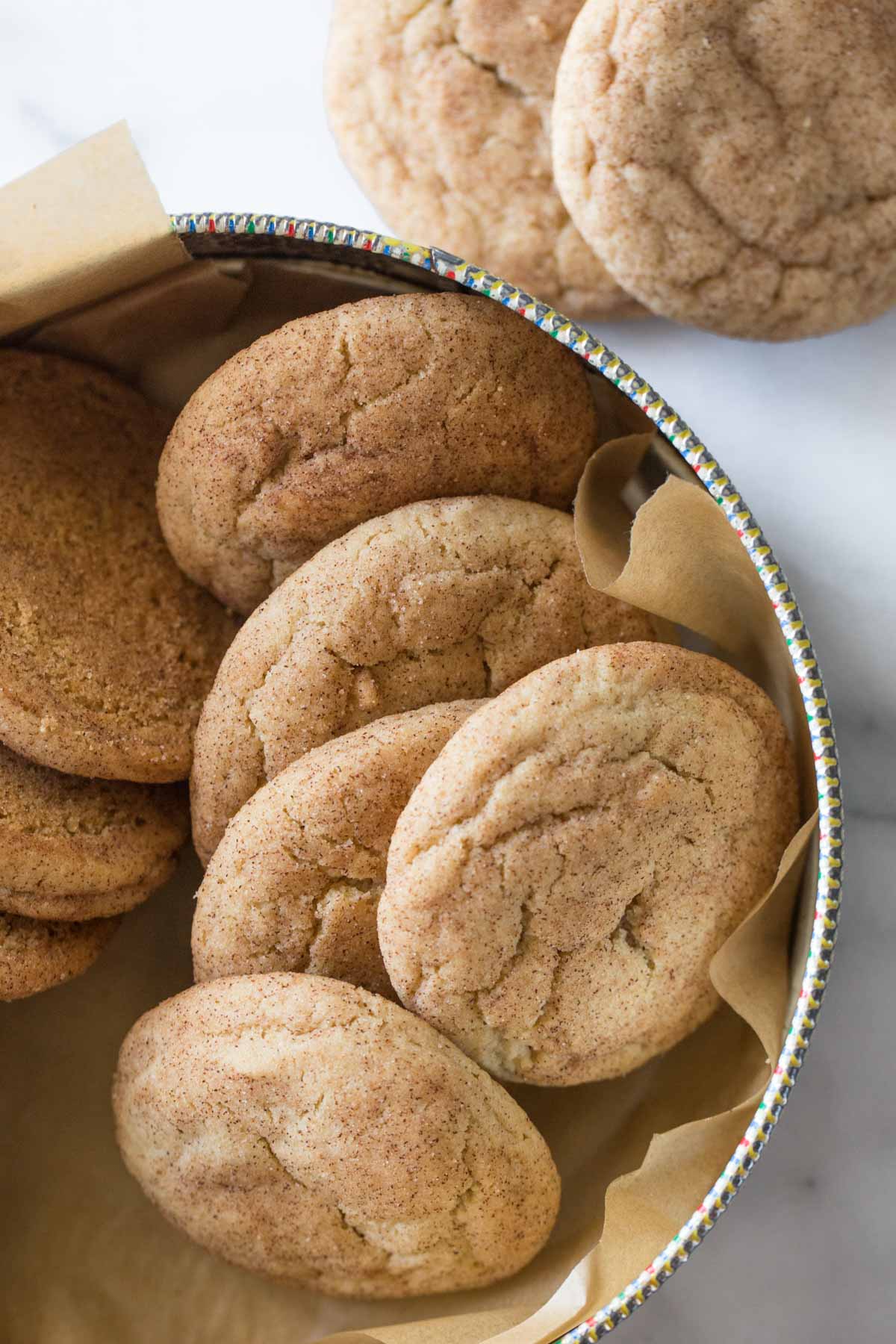 Overhead view of Super Soft Snickerdoodles in a cookie tin lined with parchment paper. 