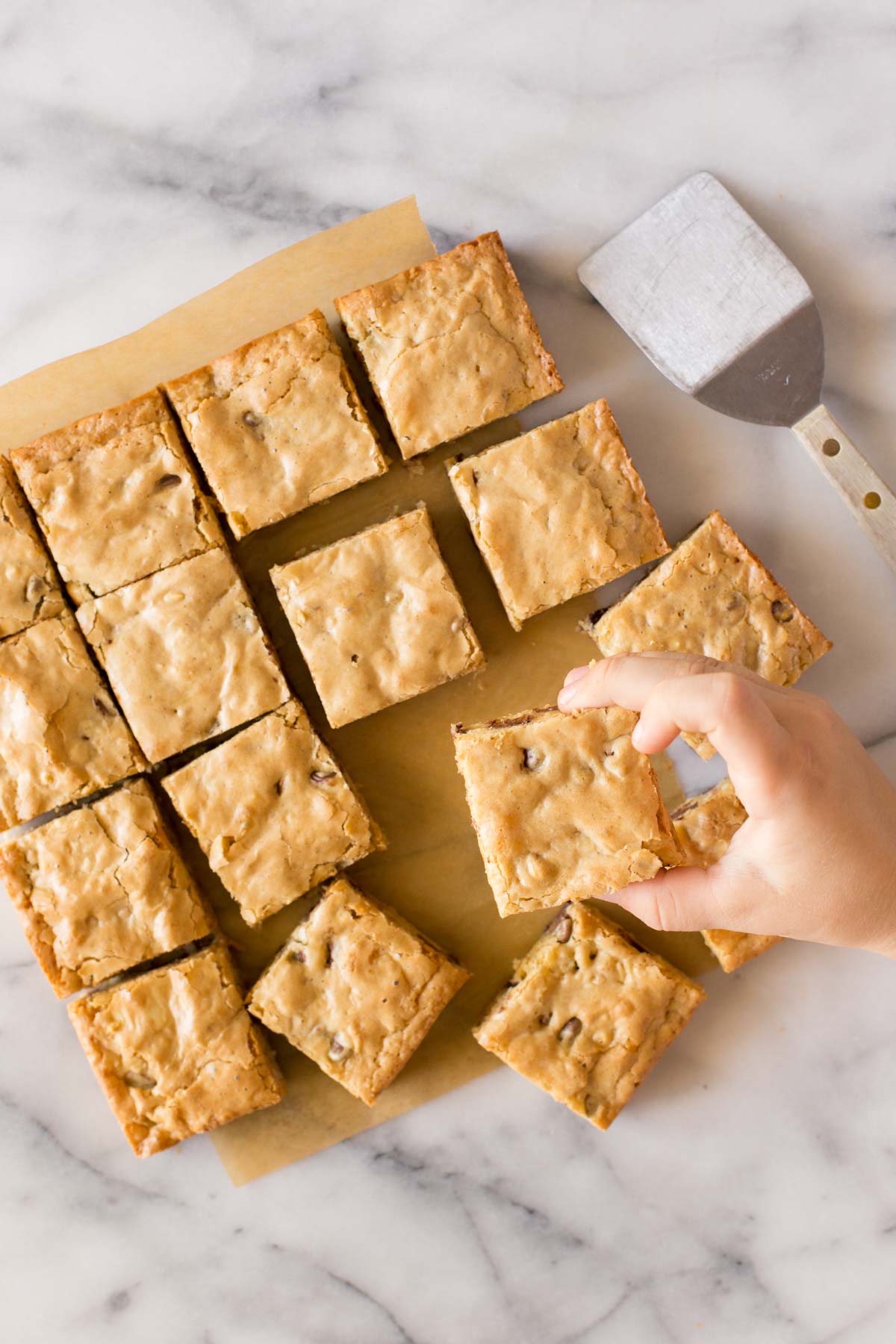 Overhead view of Easy One Bowl Blondies on a white marble background. 